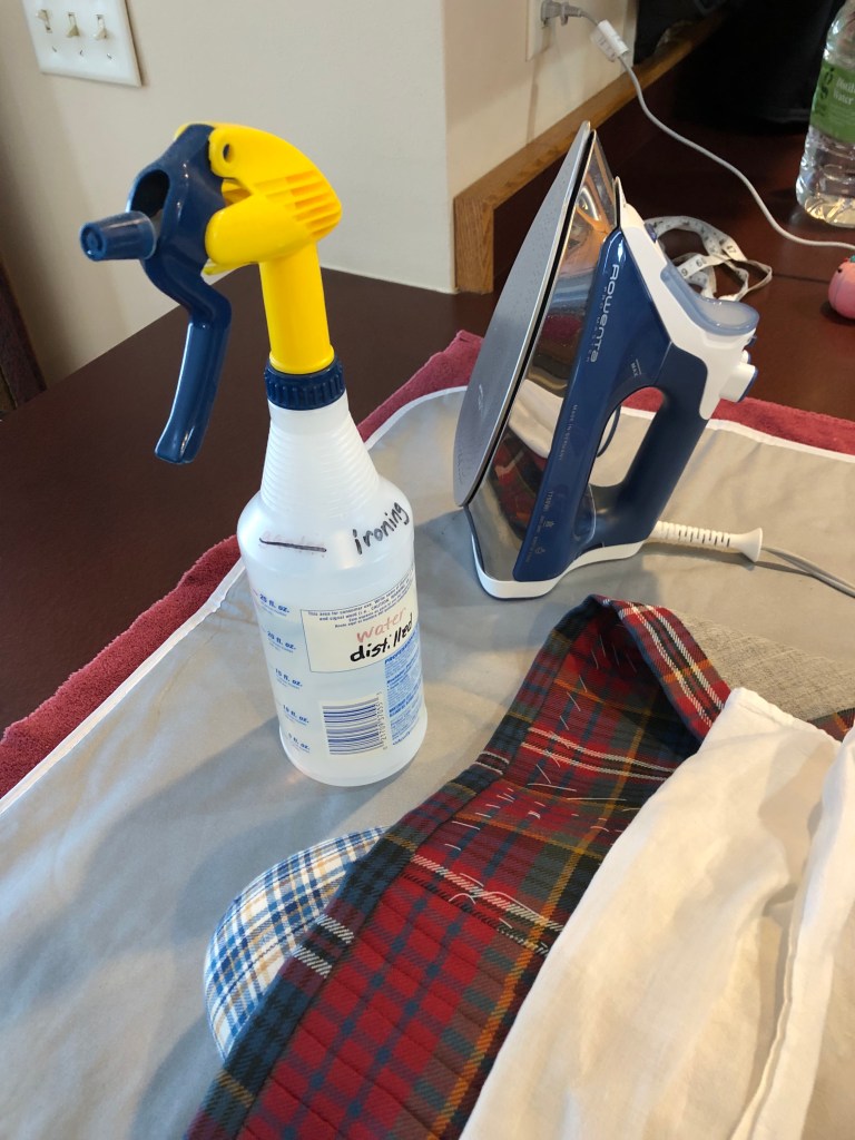 a steam iron spray bottle, pressing cloth, tailors ham, and a kilt that needs pressing